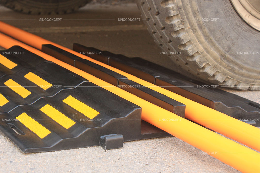 Black hose ramps made of recycled rubber with two channels to protect hoses from heavy vehicles