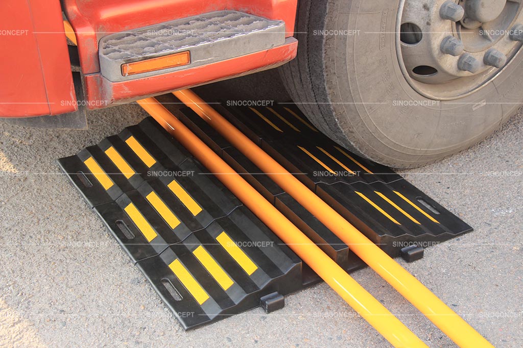 Black hose ramp pasted with yellow reflective films, used to protect hoses from heavy vehicles