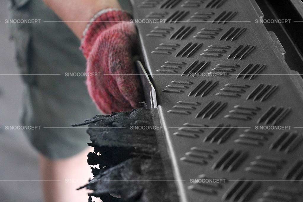 A worker is trimming a rubber cable ramp's edge