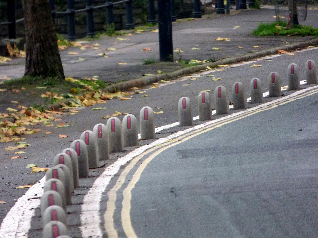 Concrete cycle lane dividers with red signs to separate a cycle lane for the cyclists' security