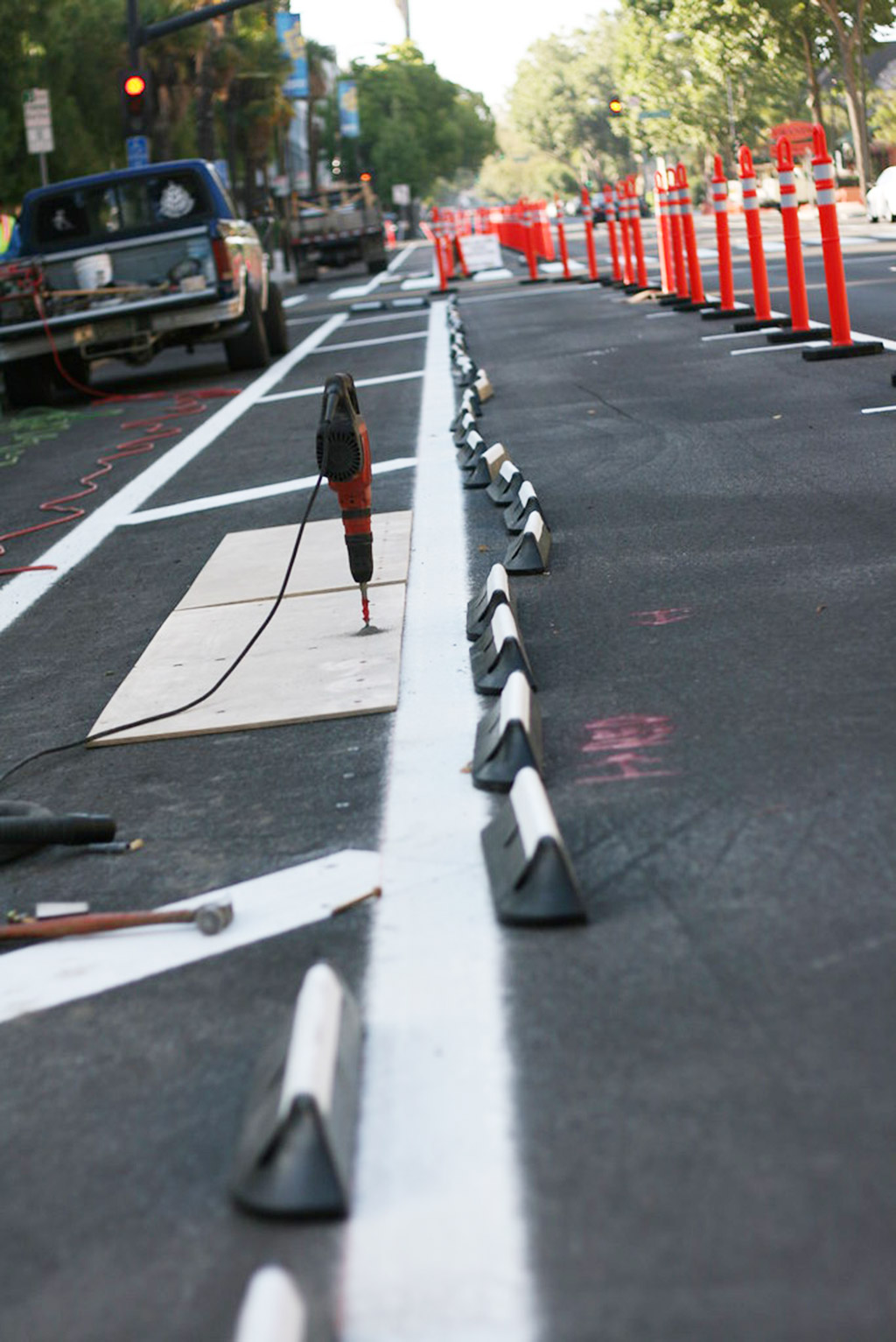 Red and black cycle lane separators pasted with white reflective films and emebedded with road studs