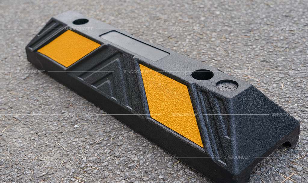 Black parking kerb made of recycled rubber with yellow glass bead reflective tapes for car park management.