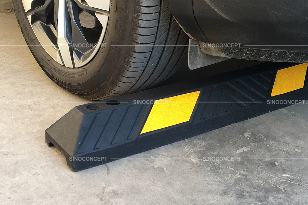 A black parking kerb pasted with yellow reflective tapes for car parking management