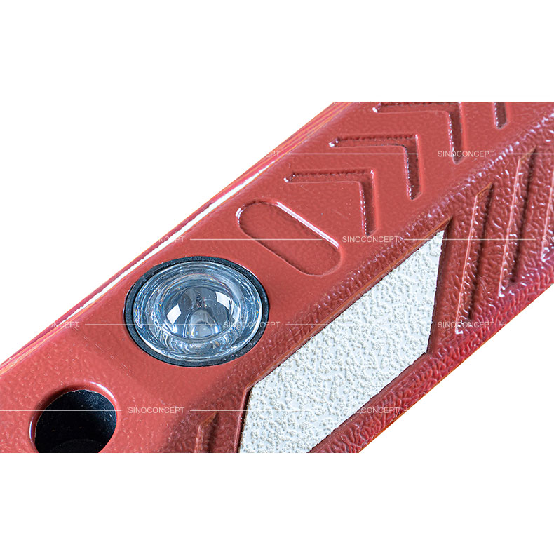 A glass road stud embedded in the red cycle lane divider made of plastic-rubber composite.