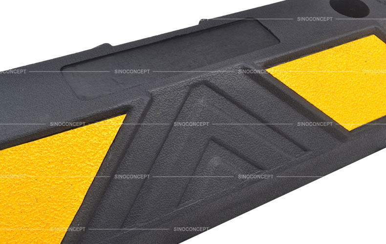 Rubber parking wheel stop surface with black rubber arrows and yellow glass bead reflective tapes for car park management