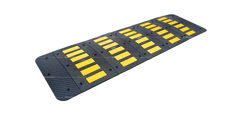 Traffic speed hump, also called speed hump, made of black rubber and yellow reflective tapes for traffic-calming purposes.