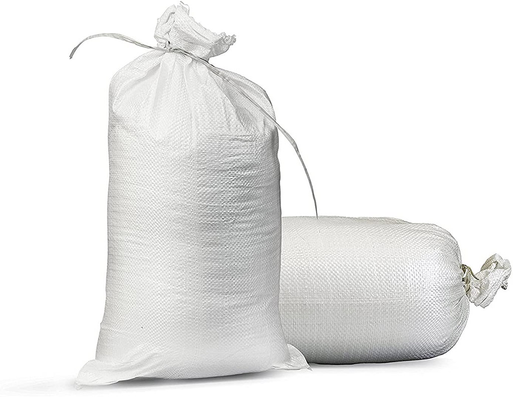 Big white bags made of woven polypropylene material, filled with sand