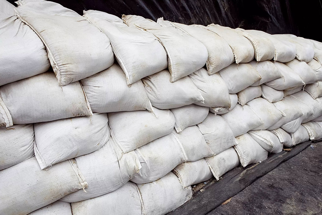 A lot of white sandbags are stacked together to prevent flooding