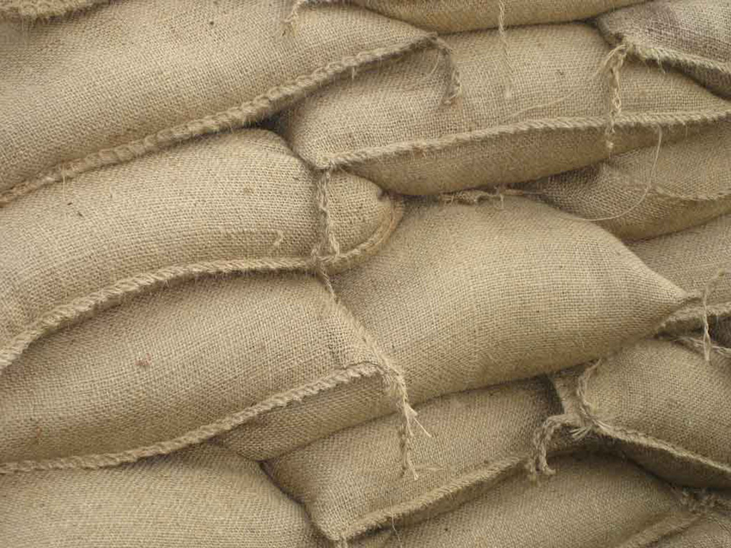 A lot of burlap sandbags are stacked together to stop flooding
