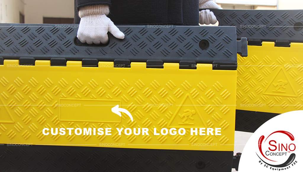 A man carrying two black and yellow cable ramps in both hands, which allows you to customise your logo on the surface.