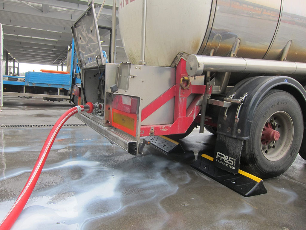 Black wheel stops made of vulcanized rubber used for heavy duty vehicles parking management