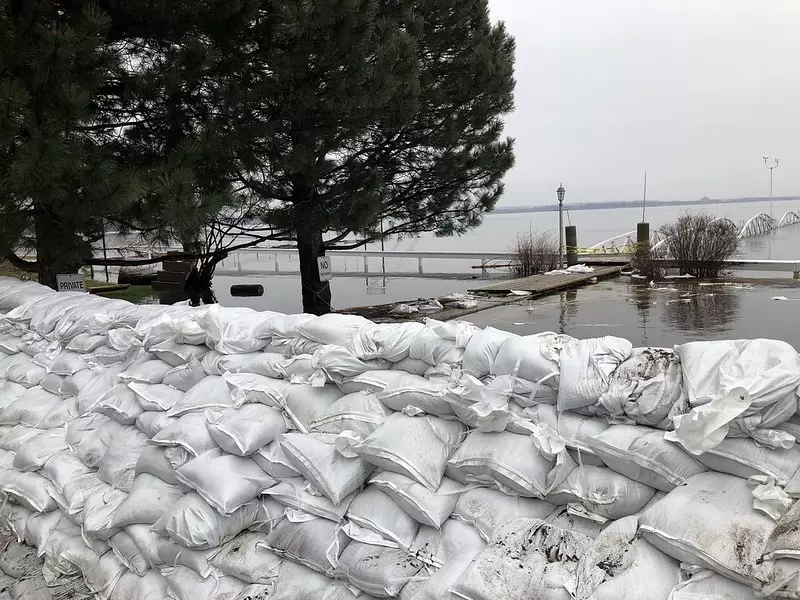 Many white sandbags are stacked together to protect against flooding.