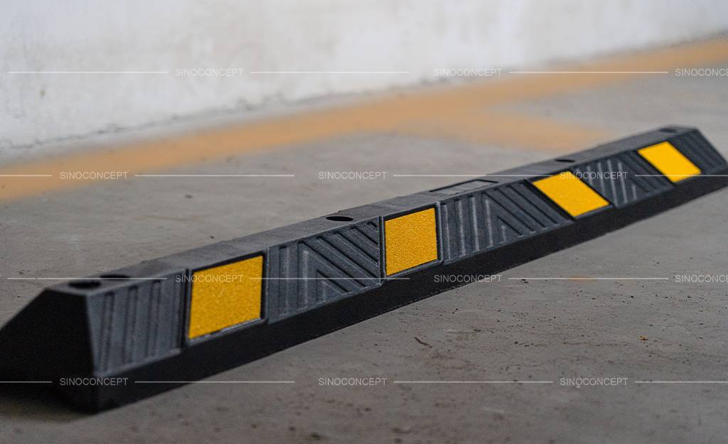 Parking block of 1830 mm made of black vulcanized rubber and yellow reflective tapes as car park equipment.
