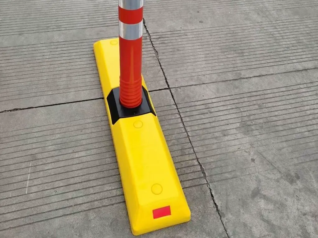 A yellow plastic lane divider with a red post on it.