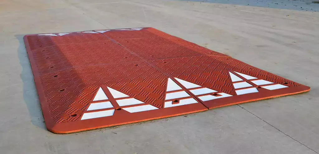 A six-part red road speed cushion made of rubber on the ground.