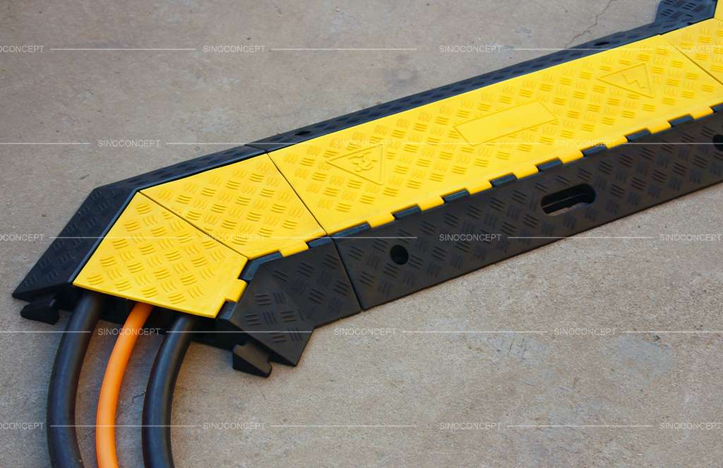 3-channel cable ramp made of rubber, also called floor cable protectors, designed with skidproof surface and yellow plastic lids.