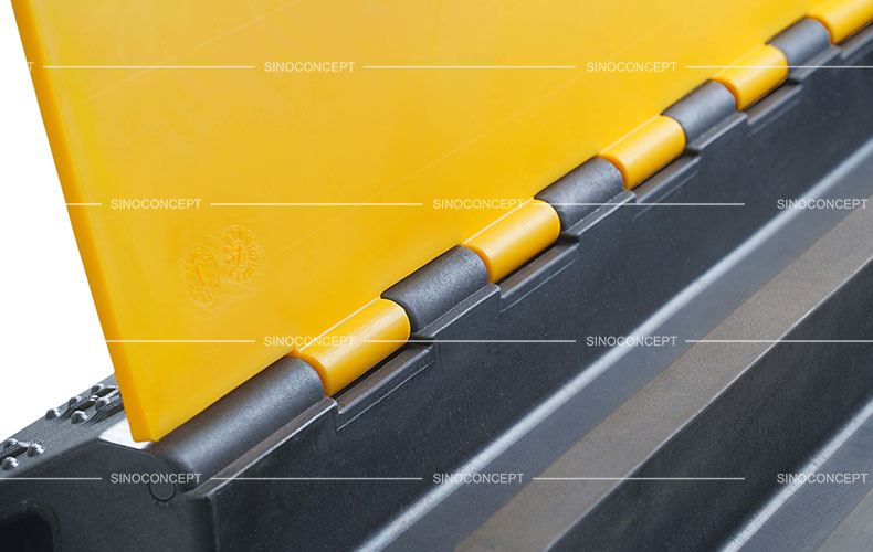 A detailed picture of a 3-channel rubber cable ramp with yellow plastic lids.