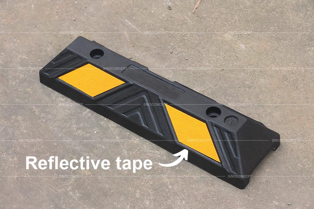 Black wheel stop made of recycled rubber with yellow reflective tapes