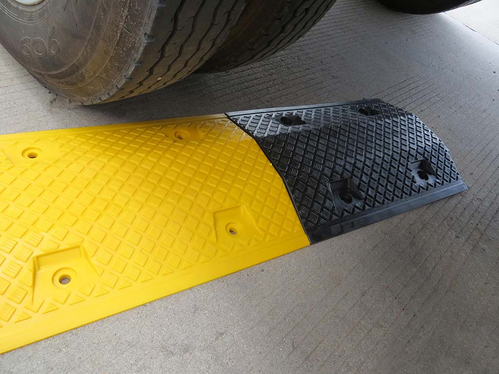 Black and yellow speed bumps also called speed ramps used as a traffic calming device