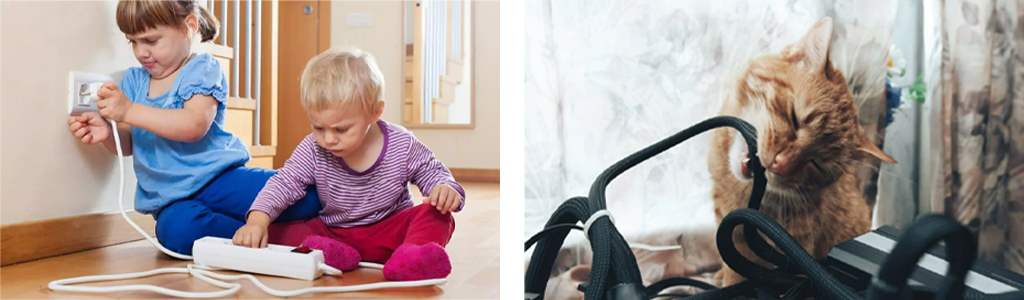 Two kids are playing with wires, and a cat is chewing on a black cable.