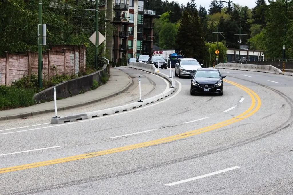 Concrete lane dividers on the road to keep cyclists and vehicles safe.