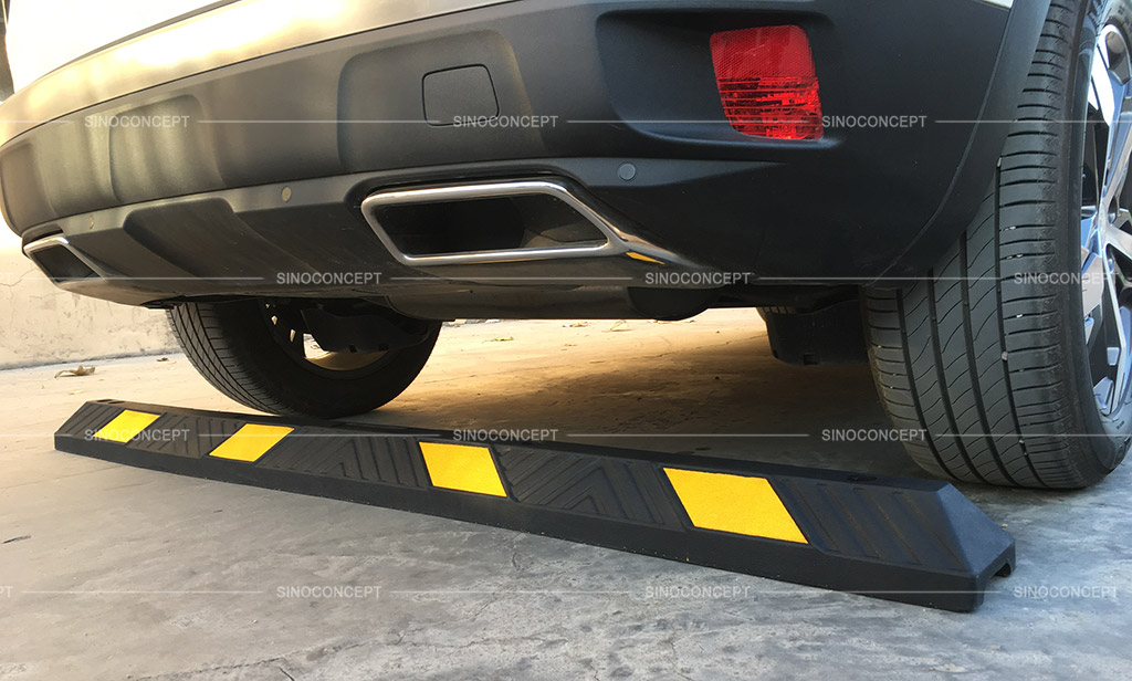 A long black parking kerb pasted with yellow reflective tapes to stop vehicle movement