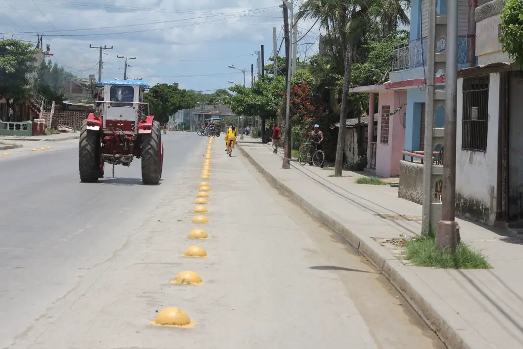 Round concrete lane dividers painted yellow on the road to separate different lanes.