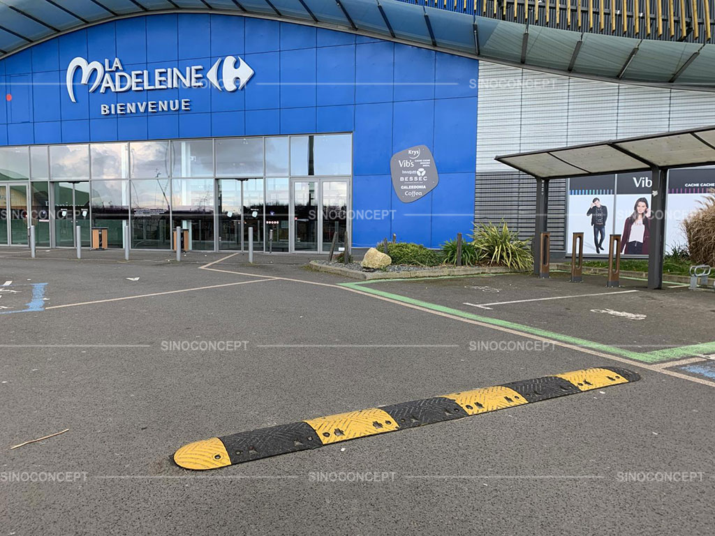 A long black and yellow speed ramp installed on the entrance of a mall for better traffic management