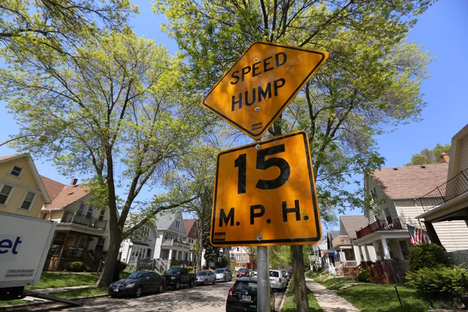 A speed hump sign indicates a speed hump around, and you should reduce your speed to under 15 mph.