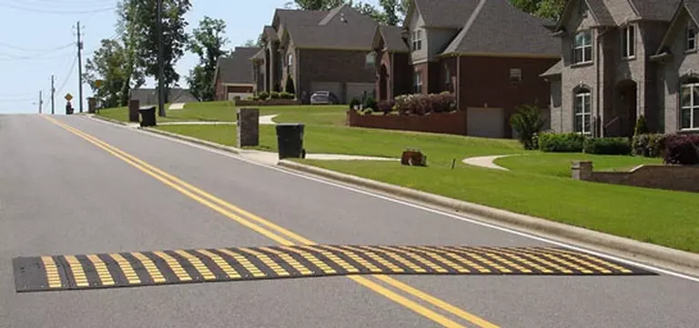 A speed hump is installed on the street to slow traffic for everyone's safety.