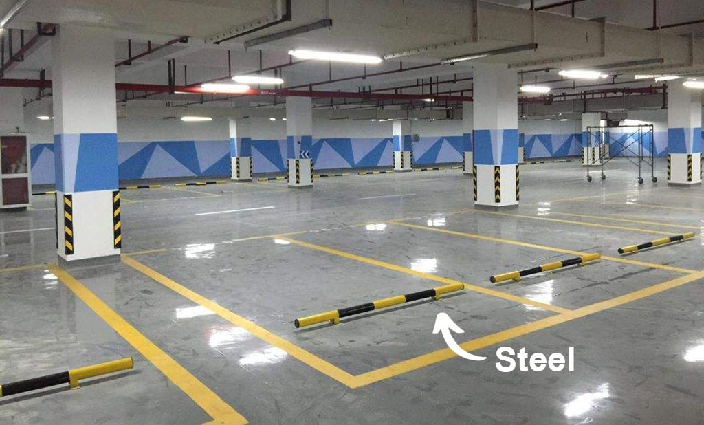 Yellow and black car stops made of steel installed in an indoor parking lot