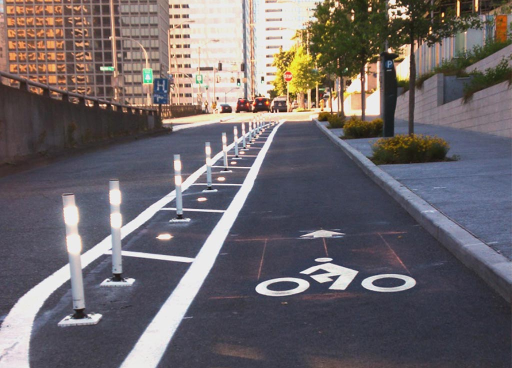 White posts are installed in a line on the road to separate a cycle lane for cyclists and led lights are equipped on those posts