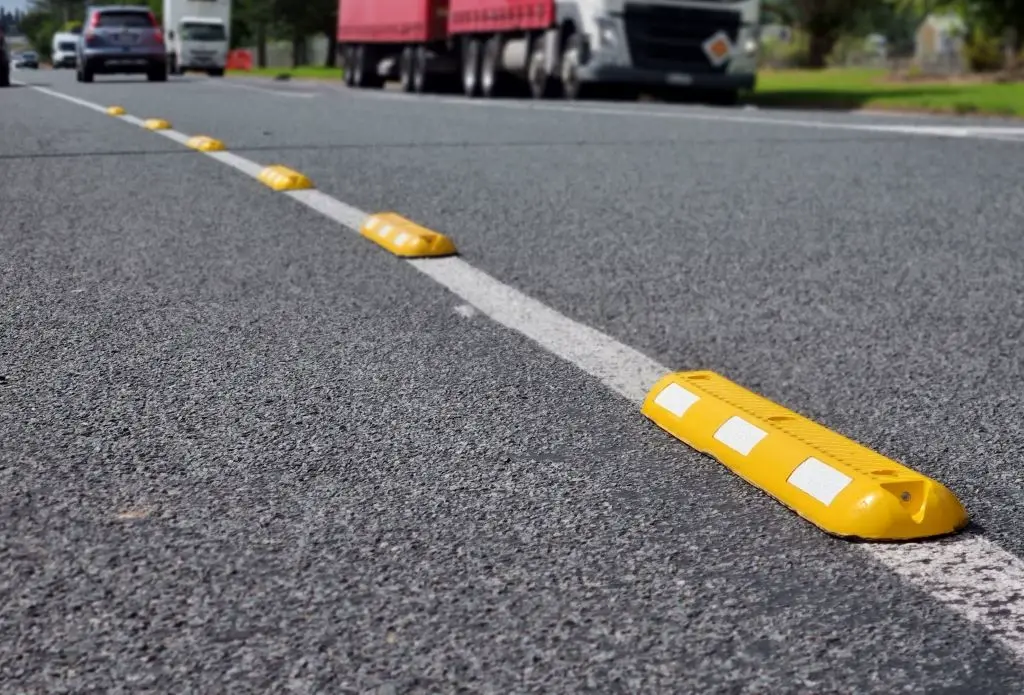 Yellow lane separators with white reflective films on the road to separate different lanes.