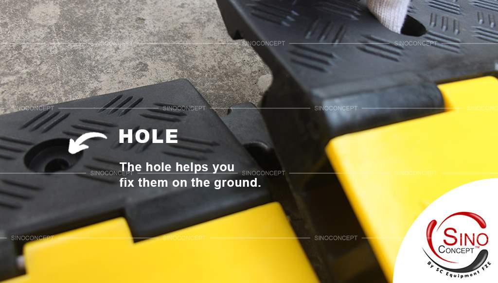A detail picture of a black and yellow cable ramp shows there are holes on the edge to help your installation.