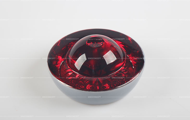 Big red glass road safety stud also called reflective road stud made of glass and steel used on roads for road safety