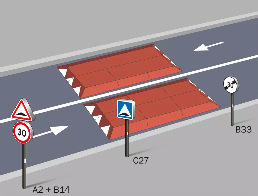 Two red Europe rubber road speed cushions are mounted on the road for traffic calming.