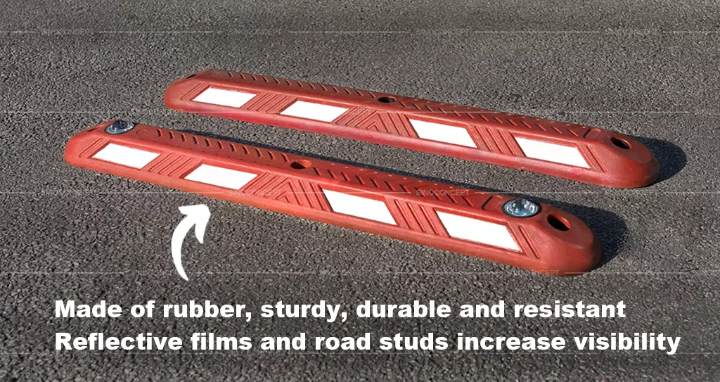 Two red road lane dividers made of vulcanised rubber with white reflective films, one of which is embedded with road studs.