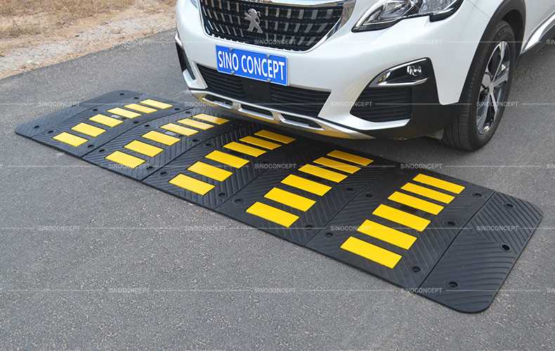 A rubber speed hump made of black recycled rubber with yellow reflective tapes for traffic safety management.