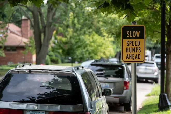 A traffic sign saying slow, speed humps ahead to warn people to slow down.