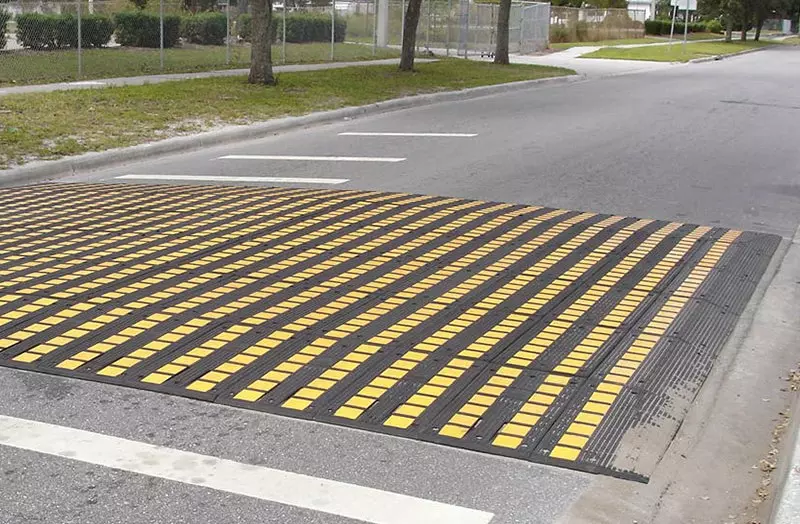 A rubber speed table mounted on the road for traffic calming.