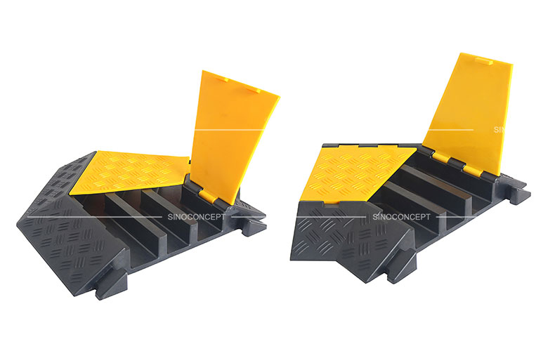 Cable protectors angle parts made of black recycled rubber and covered with yellow plastic lids to protect cables or hoses.