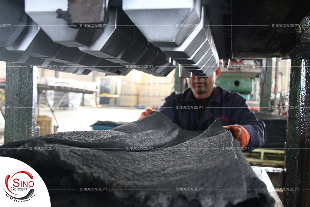 A worker put rubber material into the mould to manufacture rubber wheel stops