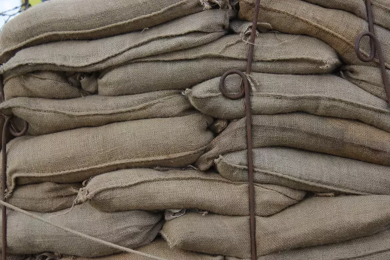 Many burlap sandbags, or you can call them hessian sandbags, are stacked together.