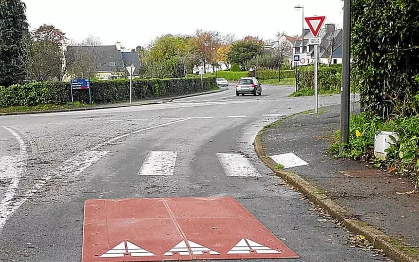 A Europe red rubber speed cushion is mounted next to the crosswalks for traffic calming.