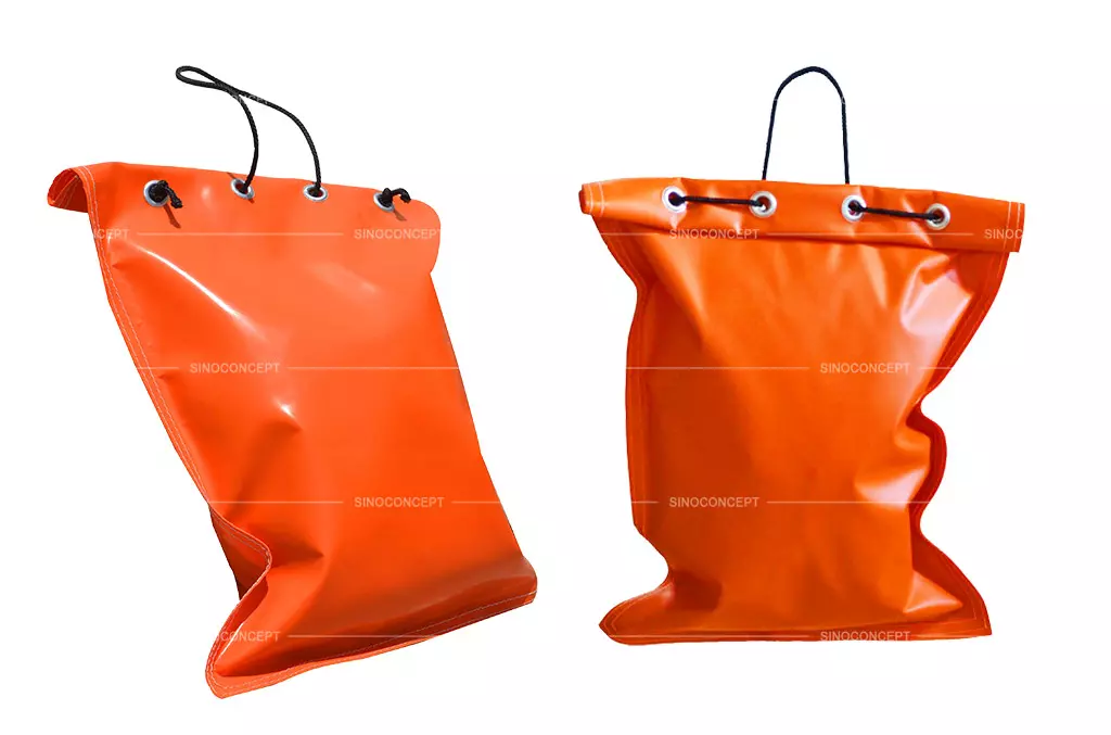 Two orange sandbags made of PVC material and filled with sand for traffic safety