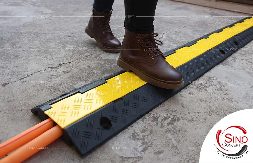 A black rubber outdoor cable cover with yellow lids to protect wires and reduce the chances of tripping.