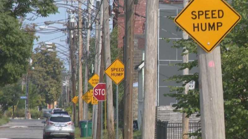 Several traffic signs saying speed hump warn people to slow down.