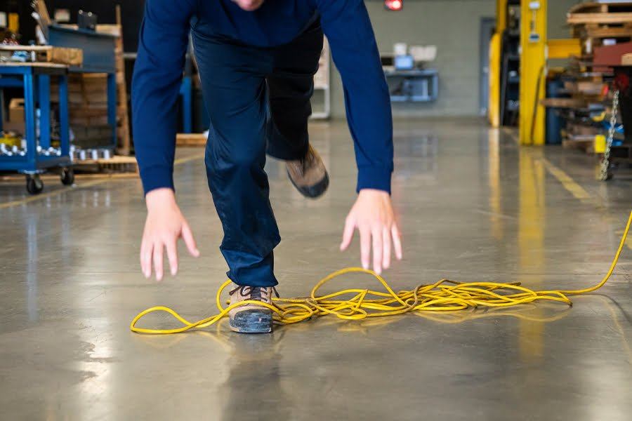 A person is tripping over the messy yellow wires on the ground.