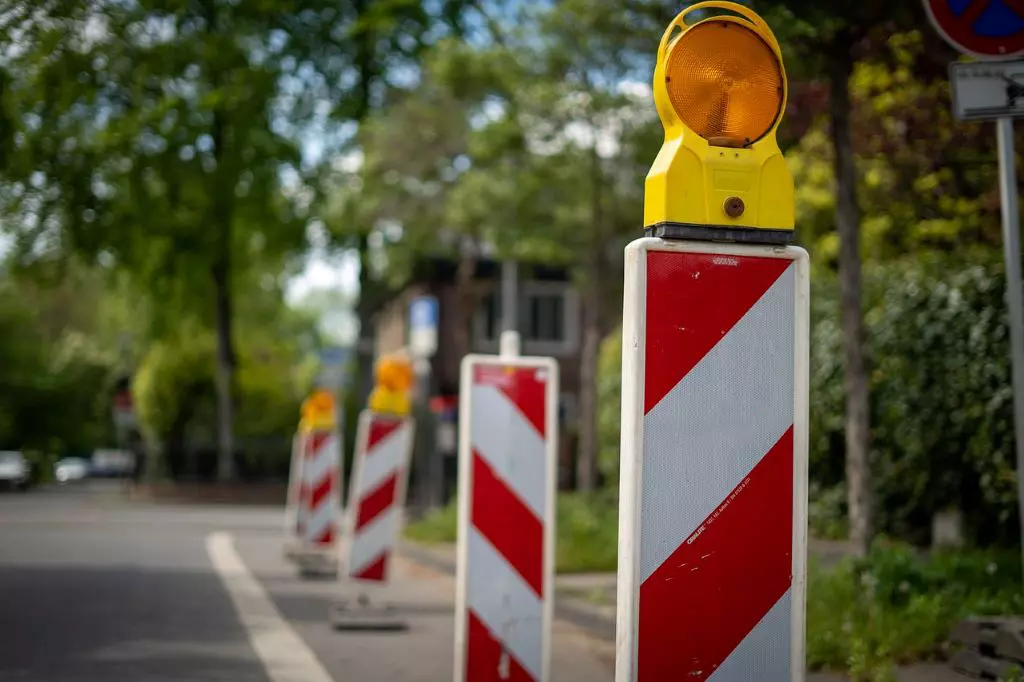 Red and white plastic road beacons with yellow lamps on the top for traffic-safety management.