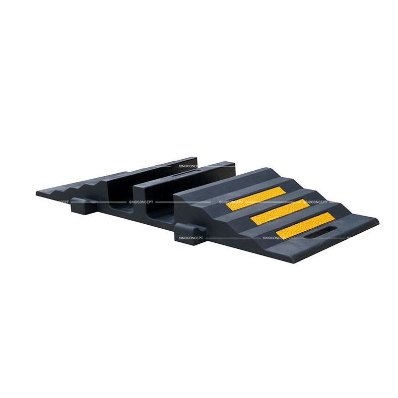 A black rubber hose protector ramp with yellow reflective films to protect hoses or cables.